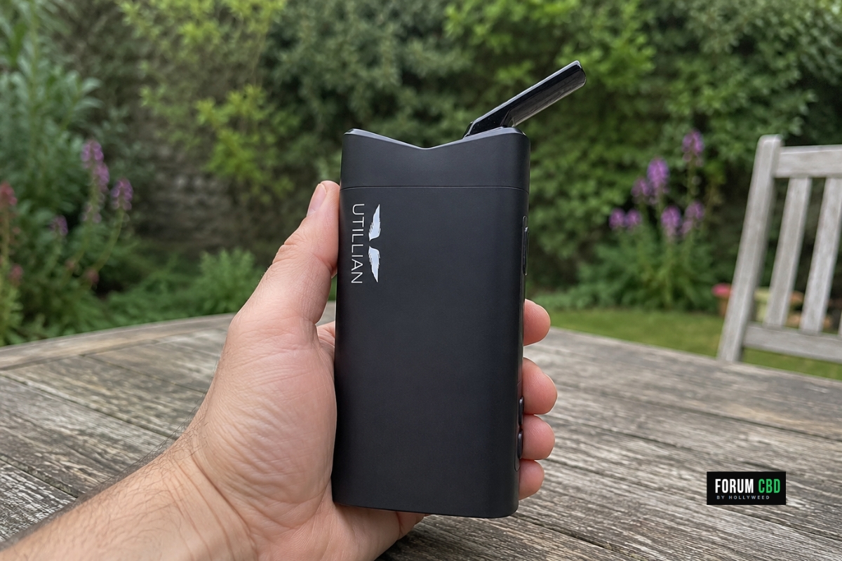 Utillian 850 tenu en main dans un jardin, avec son logo visible au-dessus d’une table en bois