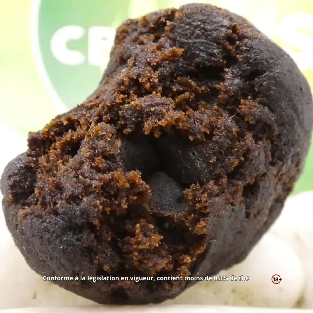 Gros plan sur une résine CBD sombre à la texture friable proposée par CBDAM’S.